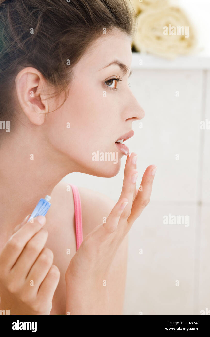 woman applying ointment for cold sore Stock Photo