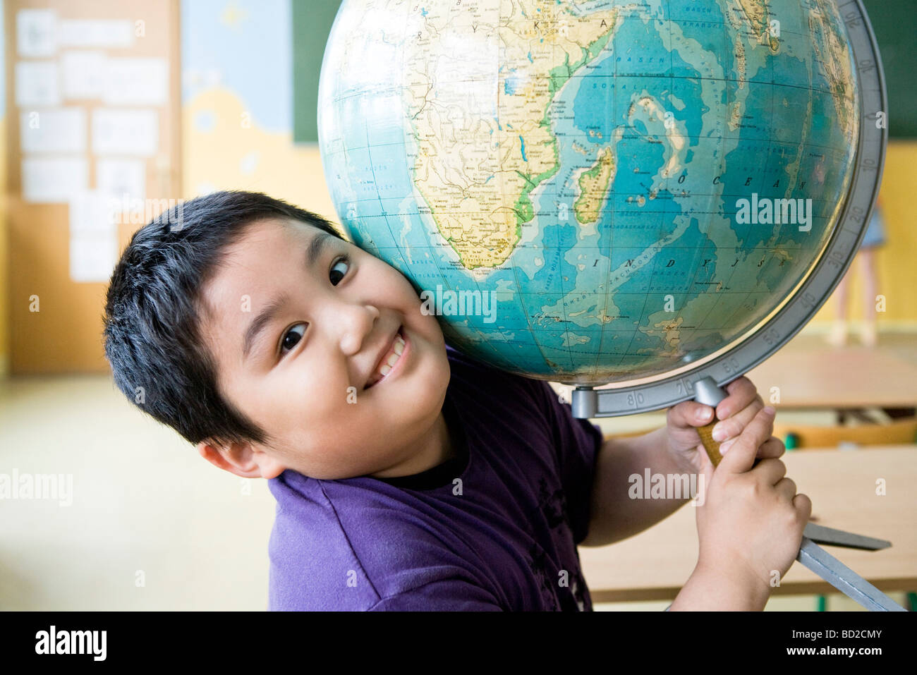 Boy With Globe In Class Stock Photo - Alamy