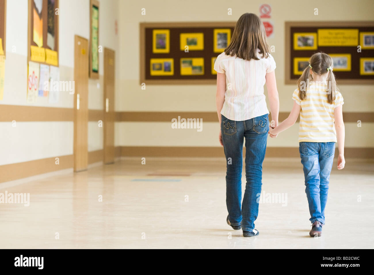 Two girls walking in school corridor Stock Photo Alamy