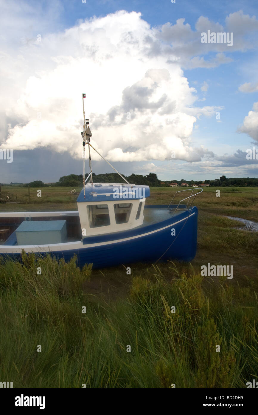 Blue fishing boat on a creek in the saltmarsh at Thornham, North Norfolk, England, UK Stock Photo