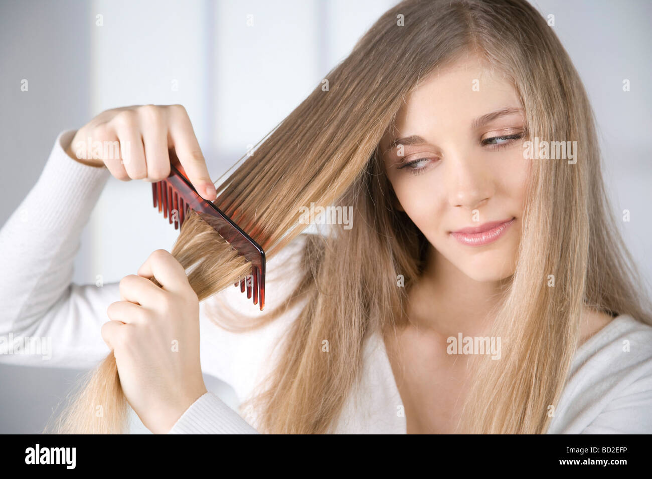 young woman combing hair Stock Photo Alamy