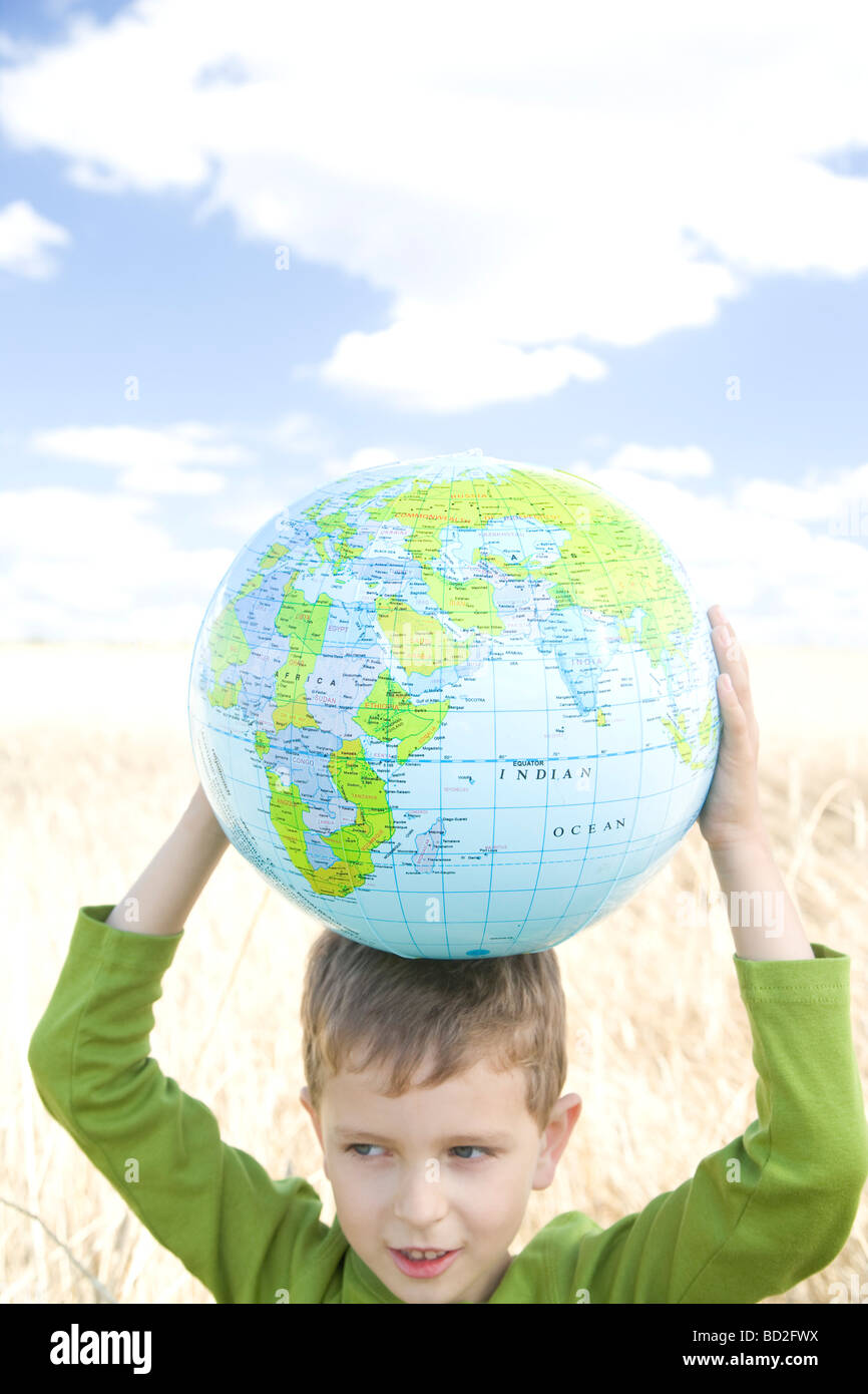 Boy playing with ball on field Stock Photo - Alamy