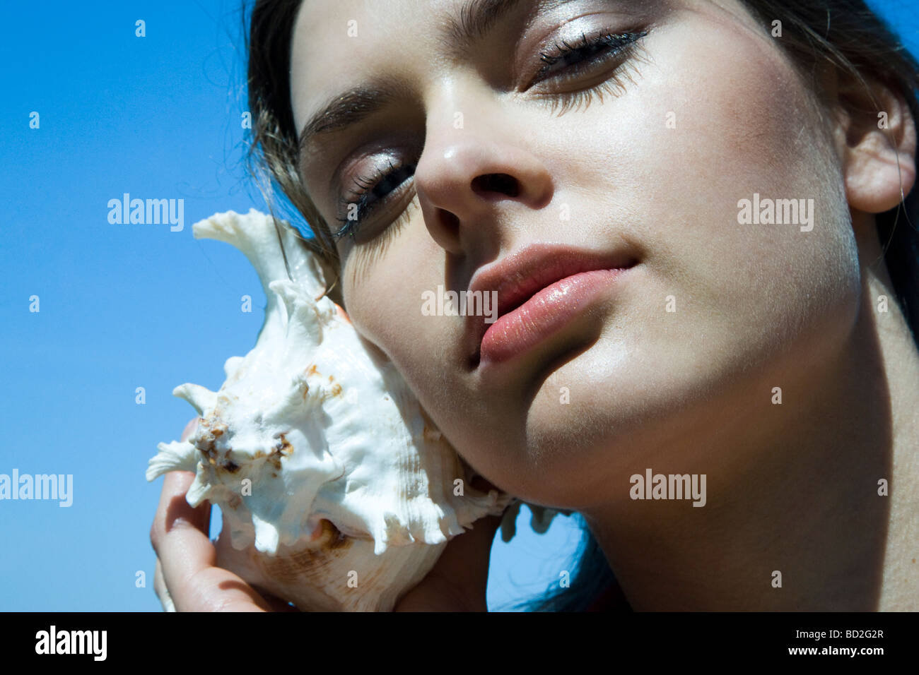 woman listening shell Stock Photo - Alamy