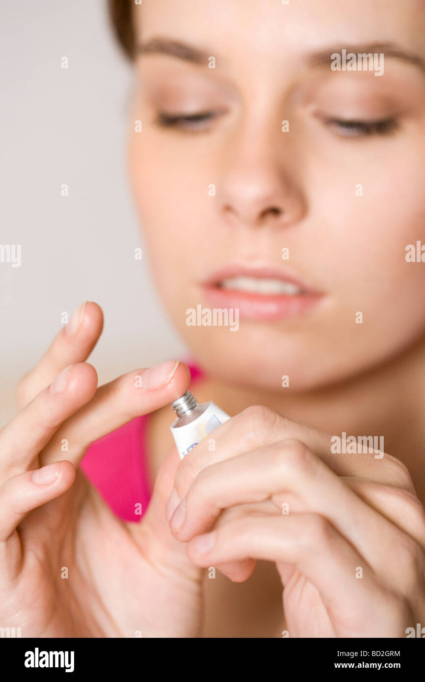 Young woman applying ointment on herpes Stock Photo