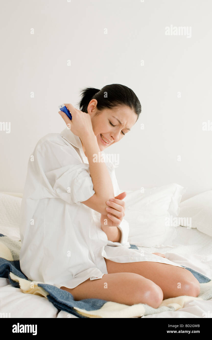 Woman putting ointment on elbow Stock Photo