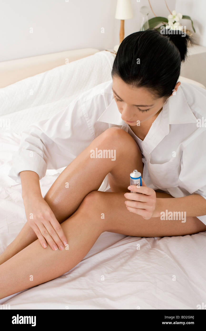Woman applying ointment on leg Stock Photo