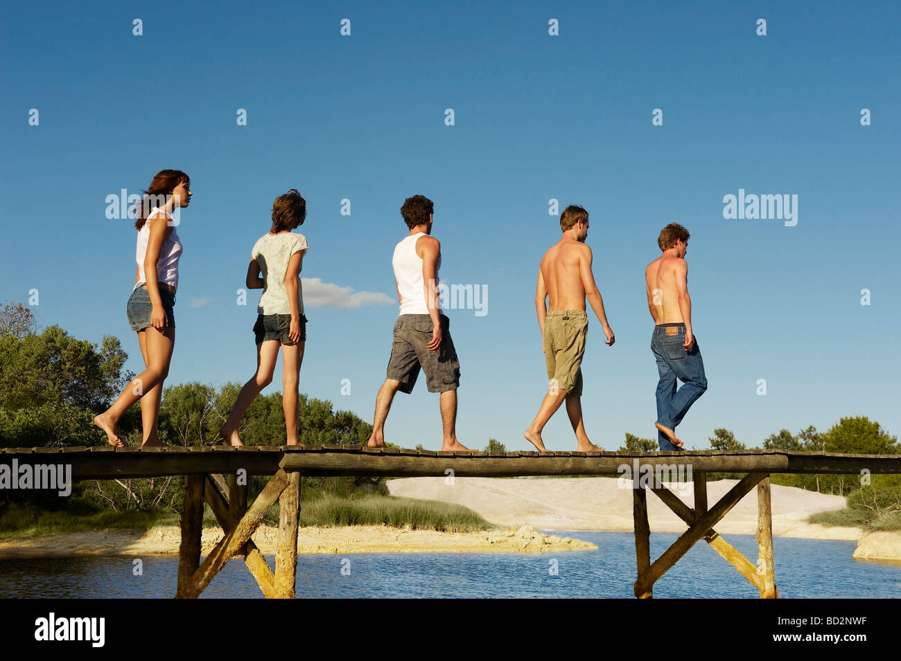 Group of young people walking on jetty Stock Photo