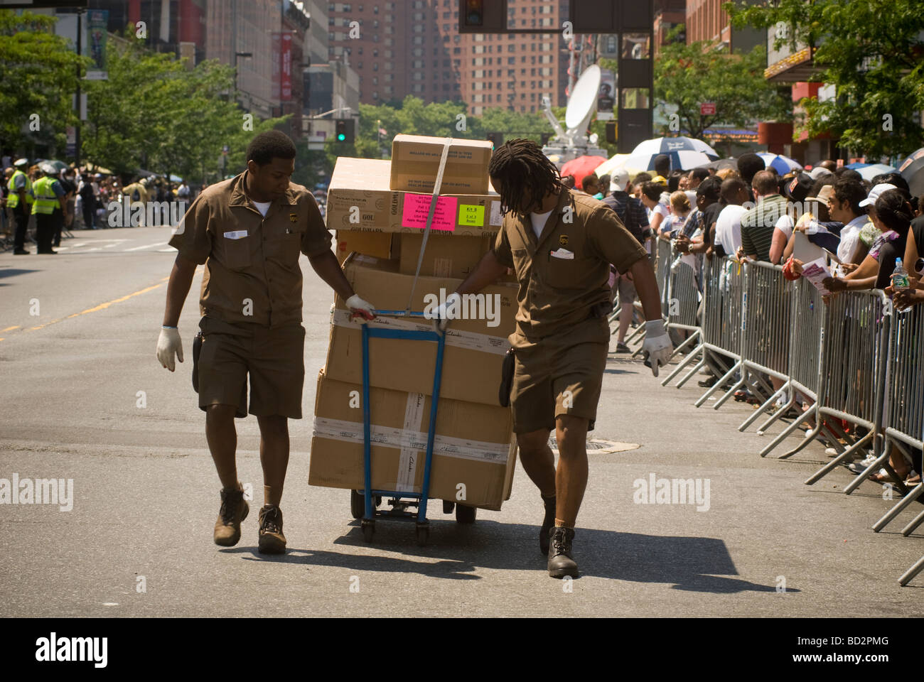 United Parcel Service couriers deliver a cart of packages in Harlem in New York Stock Photo