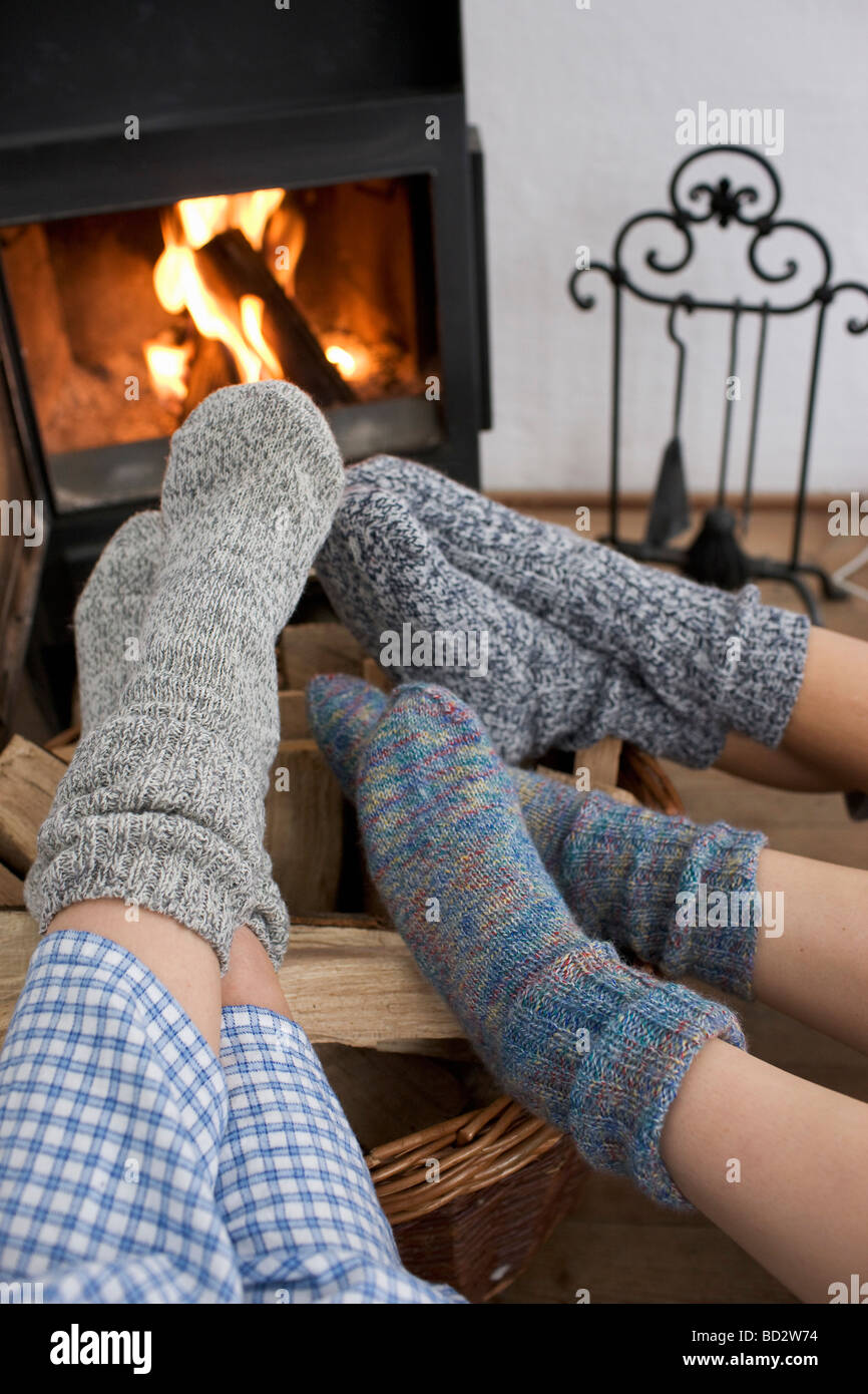 Feet warming by the fireplace Stock Photo
