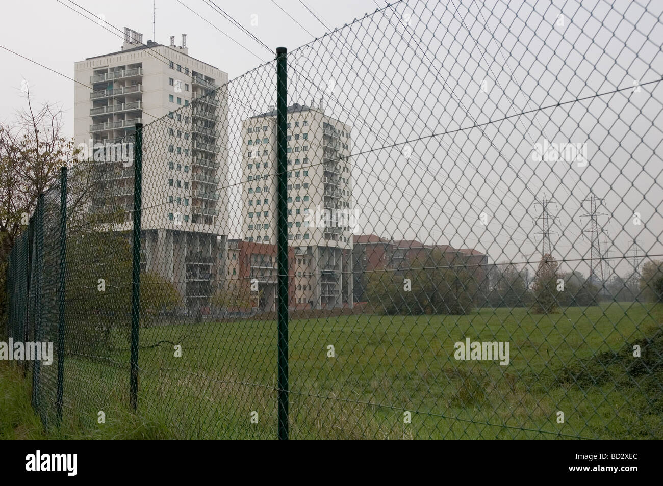 wire fence under overhead power lines near tower blocks in Quartiere