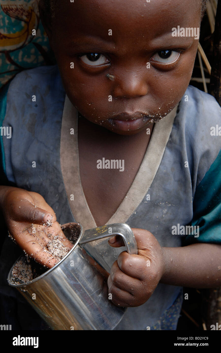 An Internally displaced child eating with his hand  in a makeshift IDP camp in North Kivu, DR Congo Africa Stock Photo