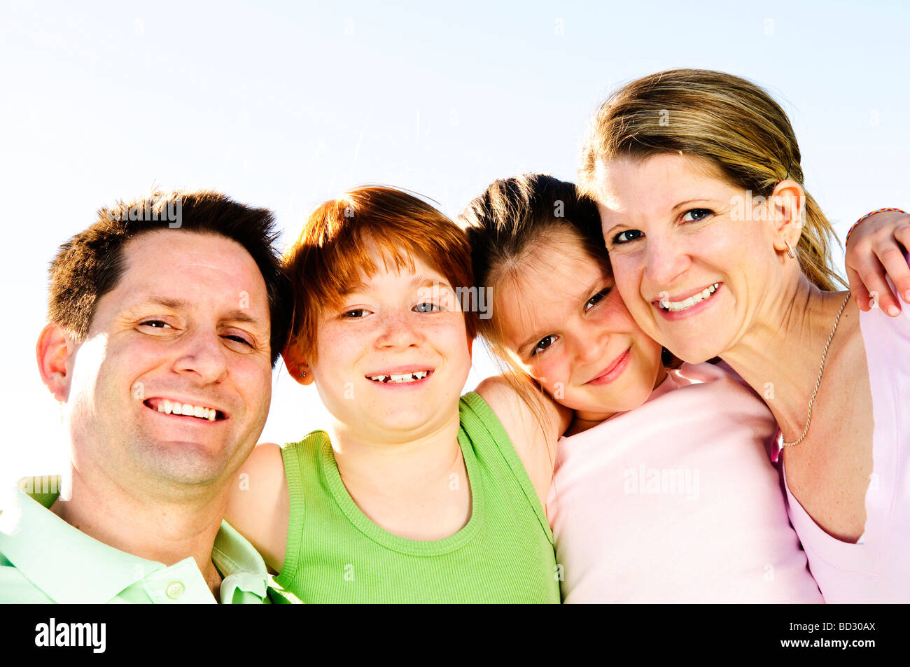 Portrait of happy family of four hugging and smiling Stock Photo - Alamy