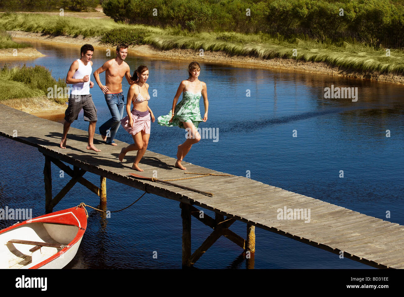 Group of young people running on jetty Stock Photo
