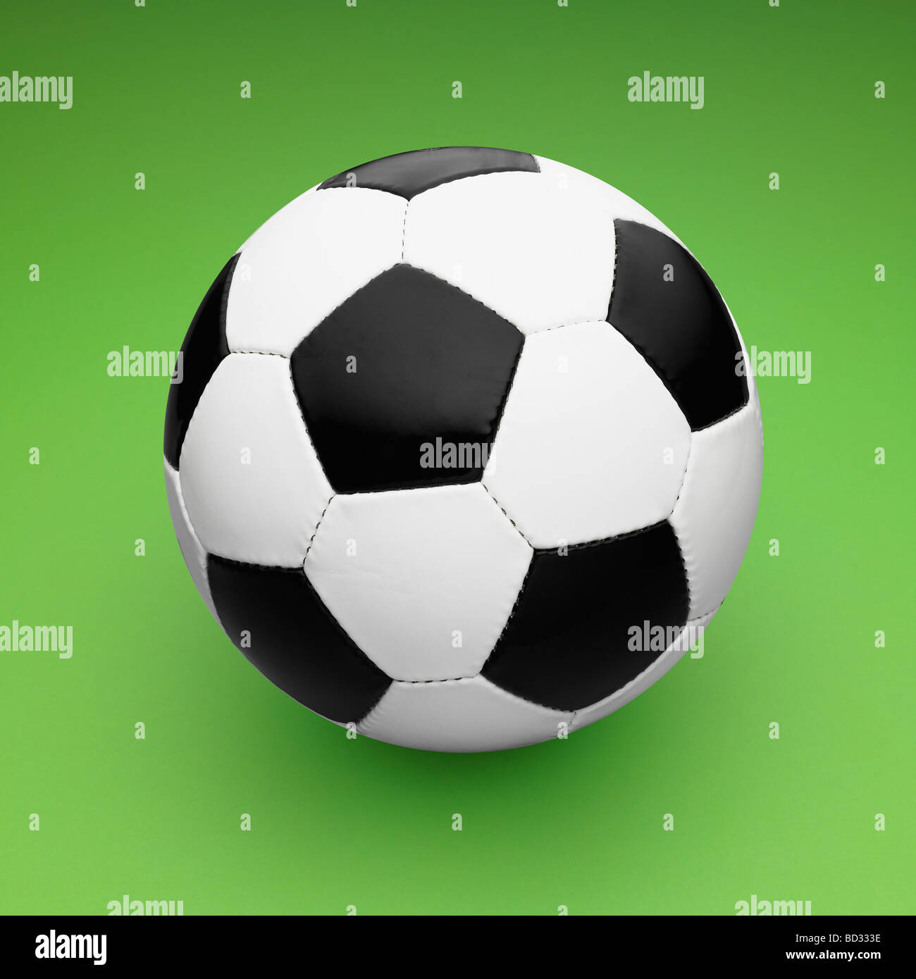 Black and White  Leather Football / Soccer Ball on Green Background. Stock Photo