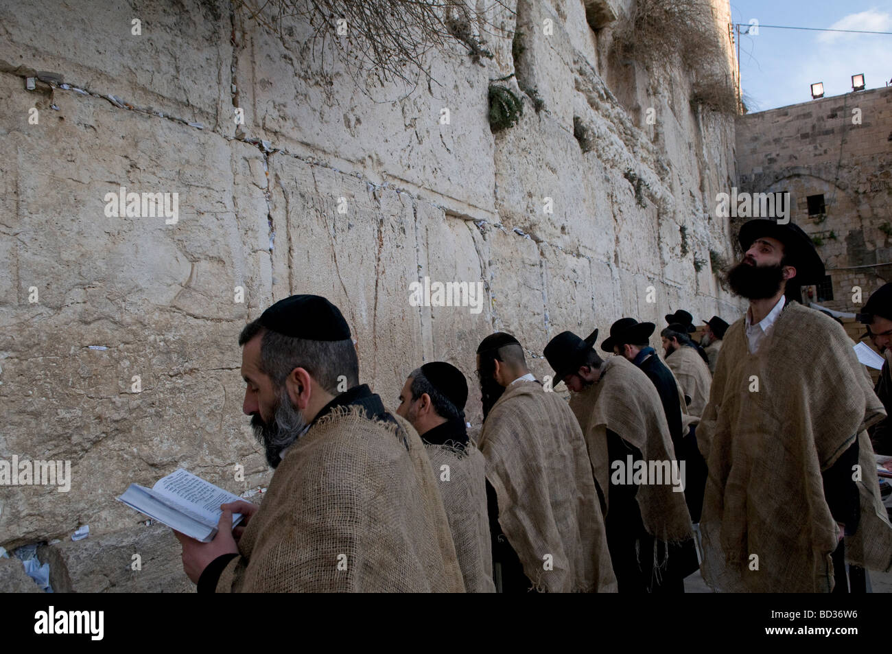 Haredi Jews wearing jute bag to signify grief pray on Tisha B'Av commemorating the destruction of the First and Second Temple in the Western Wall Stock Photo