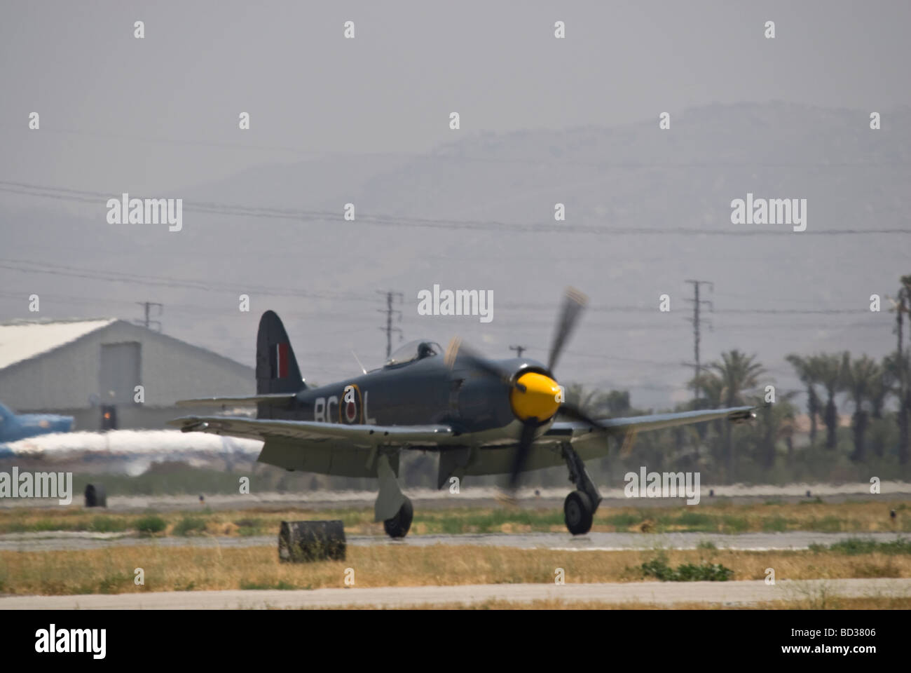 A Hawker Sea Fury touches down on the runway after flying at an air show. Stock Photo