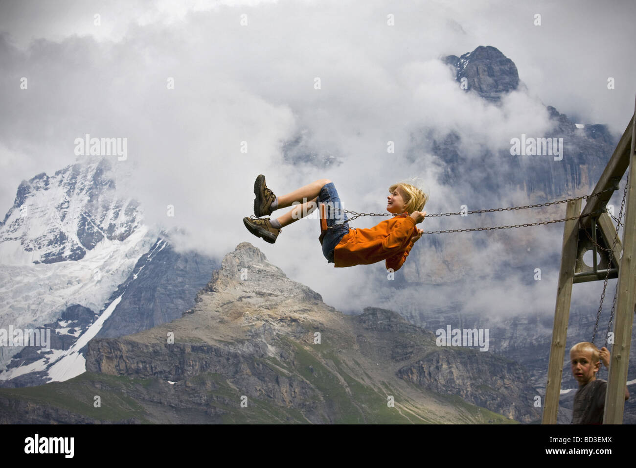 Boy playing on swing Switzerland Stock Photo - Alamy