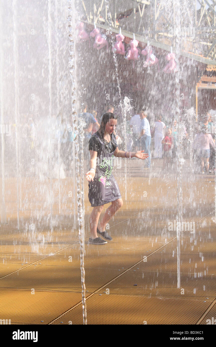 Soaked girl cooling down under fountain Stock Photo