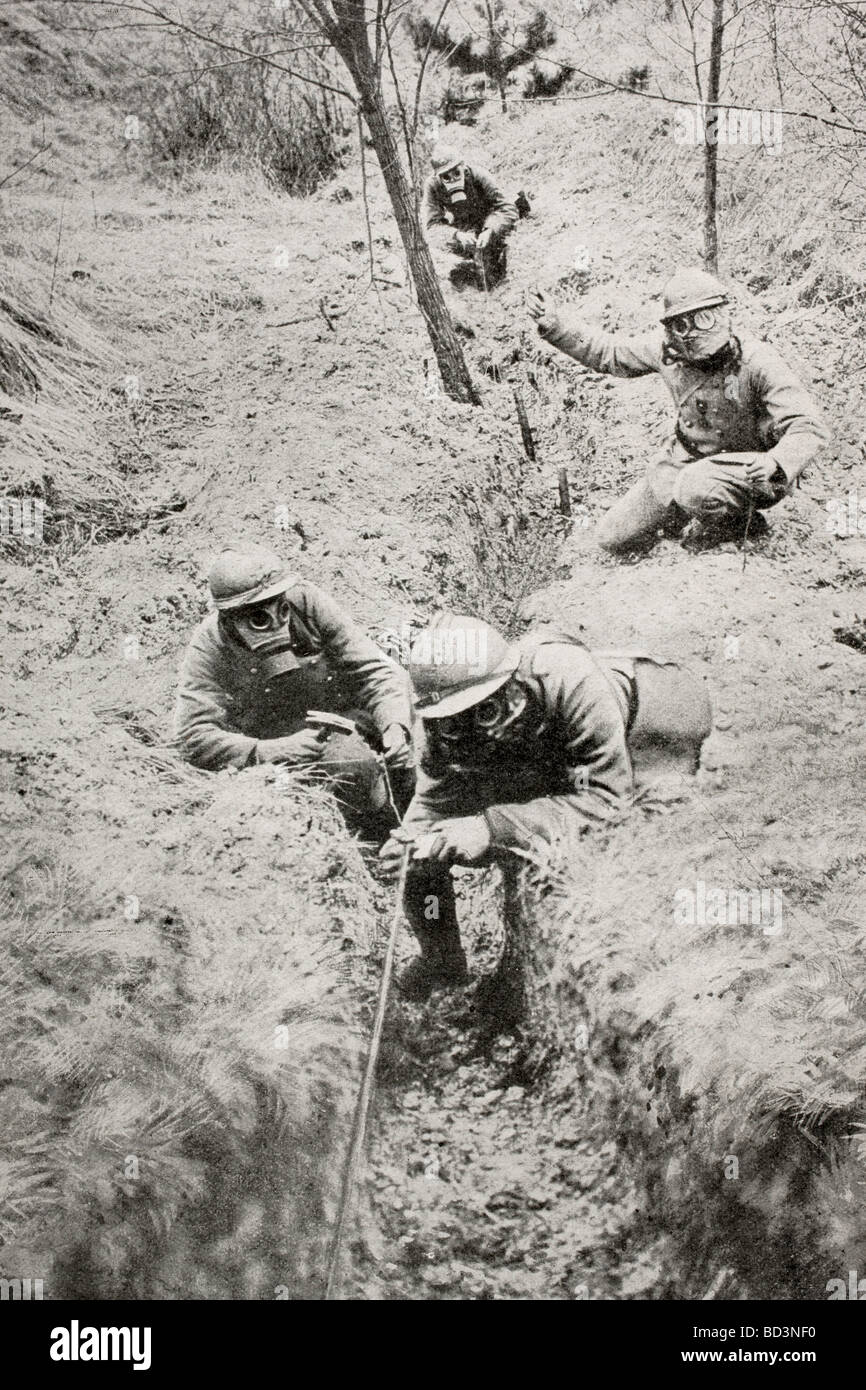 French soldiers wearing gas masks lay telephone lines behind the front line during World War One Stock Photo