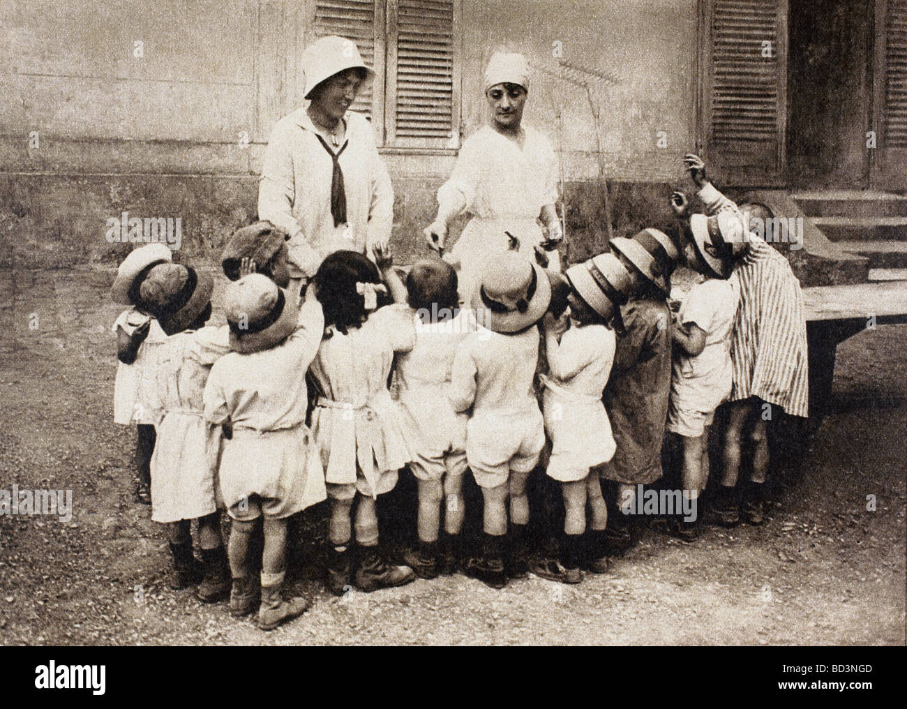 Orphans and refugee children being given pieces of chocolate at chateau de Grand Val in Sucy en Brie France. Stock Photo