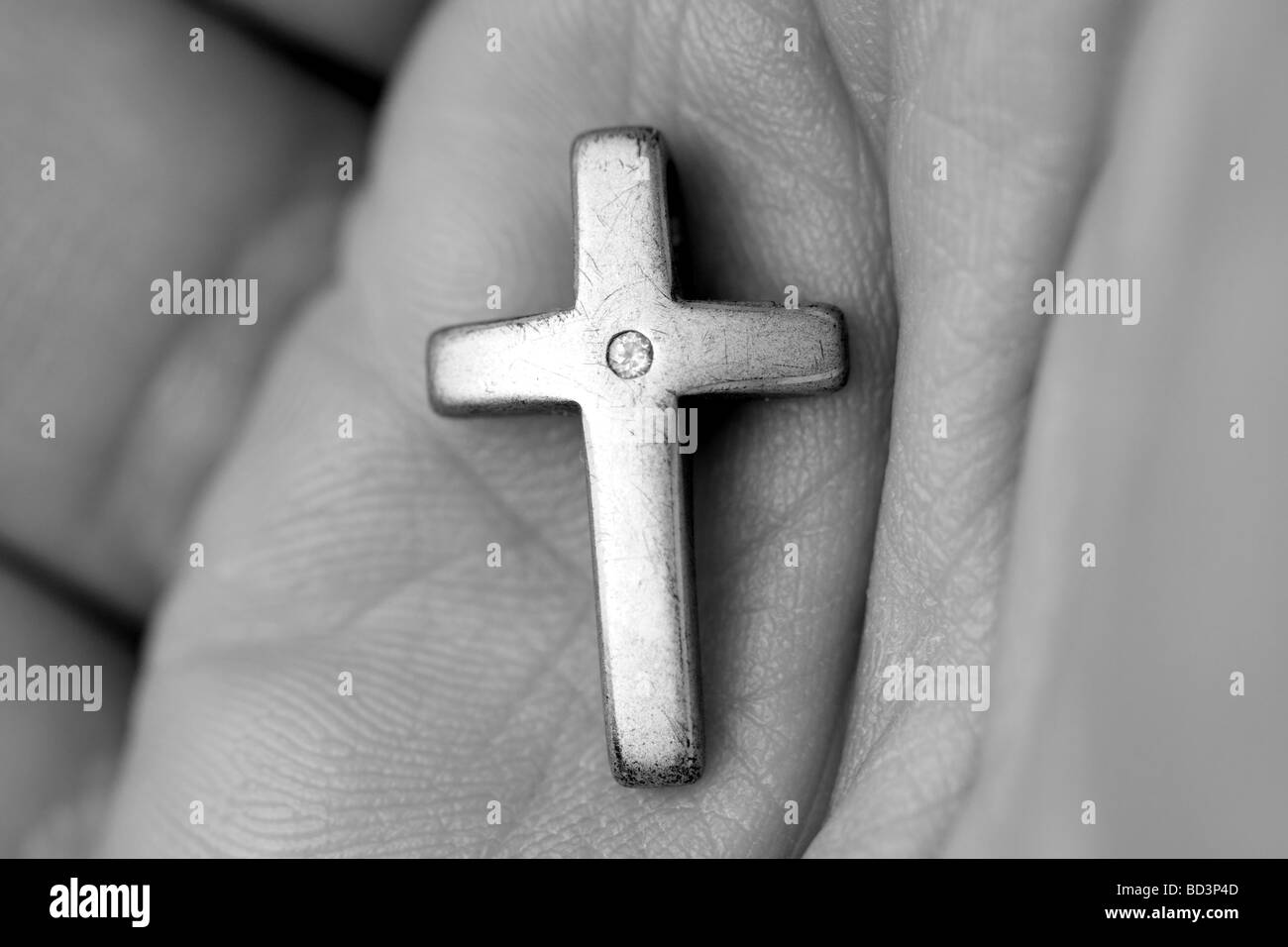 Faith Christian holy crucifix cross held in the palm of a believers hand Stock Photo