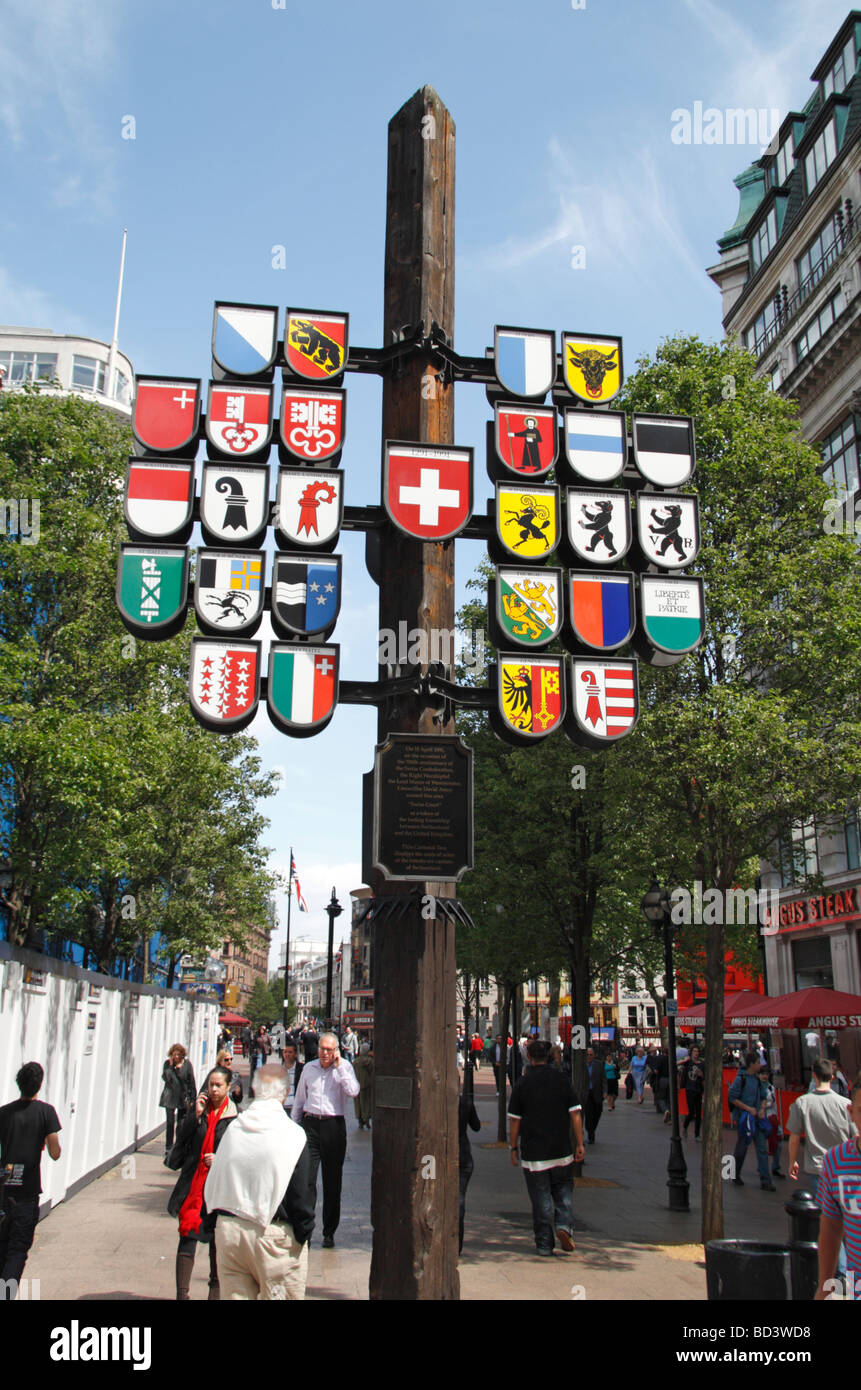 A cantonal tree, displaying the regional flags of Switzerland, at the western entrance to Leicester Square, London, UK. Stock Photo