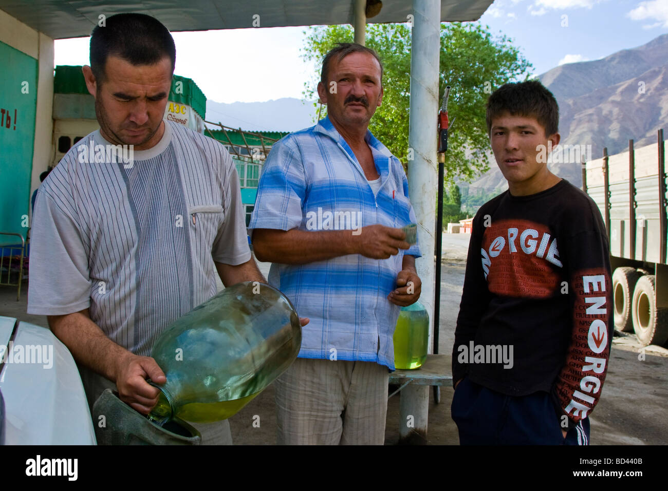 Filling Car with Fuel from large glass jars in Tajikistan Stock Photo