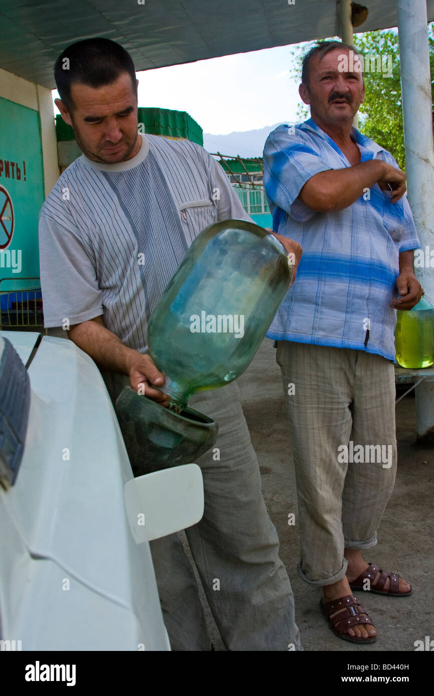 Filling Car with Fuel from large glass jars in Tajikistan Stock Photo