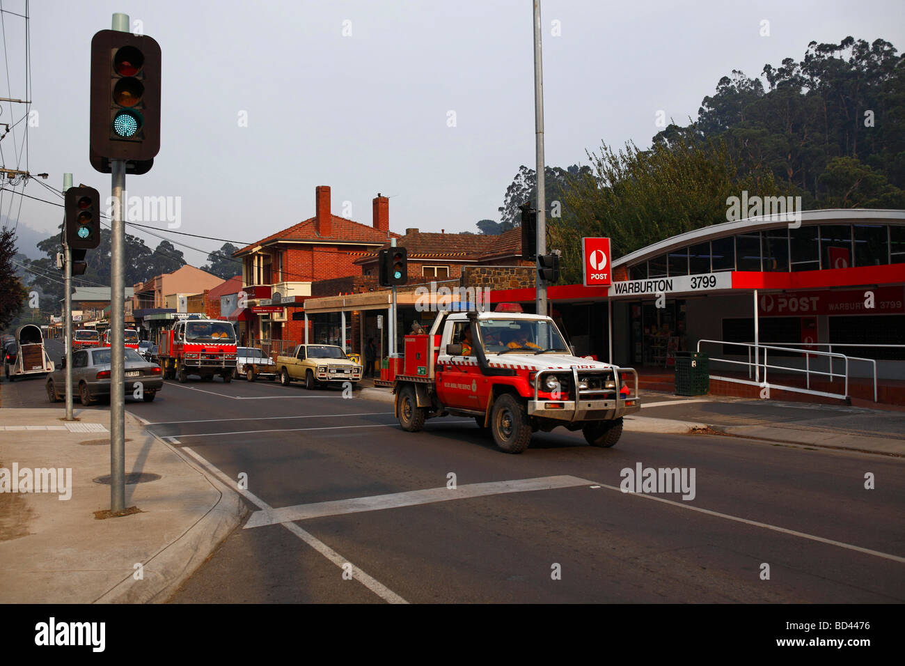 Smoke in the air as fire trucks drive down the Warburton main street Victoria Australia Stock Photo