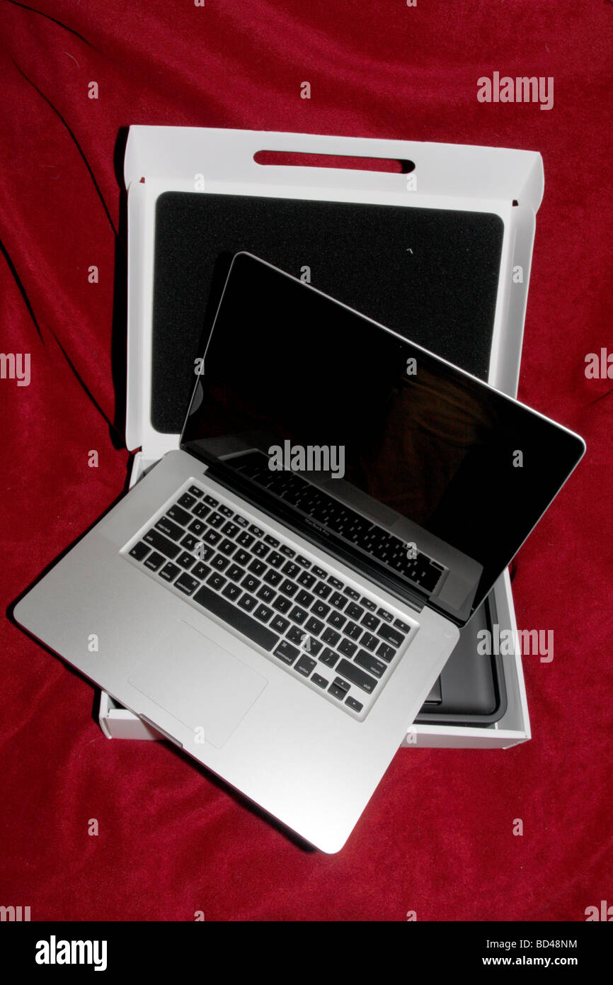 Macbook Pro 2.83 aluminum laptop computer on red. Stock Photo
