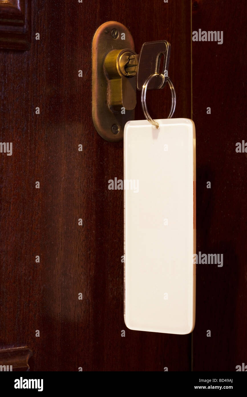 Key in a door lock featuring a blank white key fob with copyspace Stock