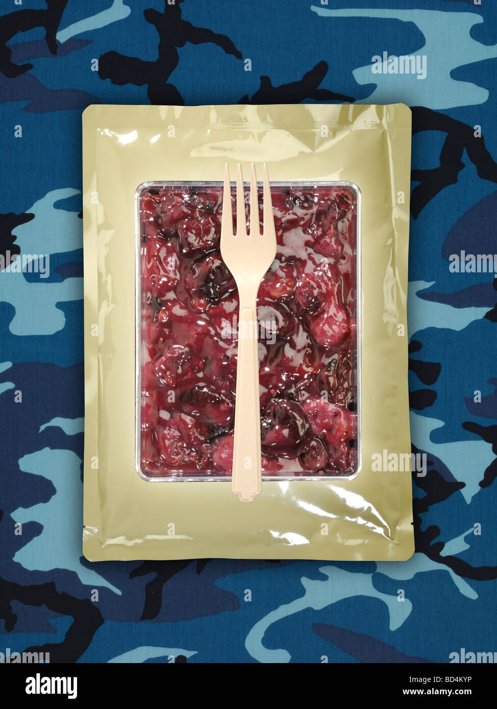 Military food ration package with utensil on a background of blue camouflage, blueberry cherry cobbler Stock Photo