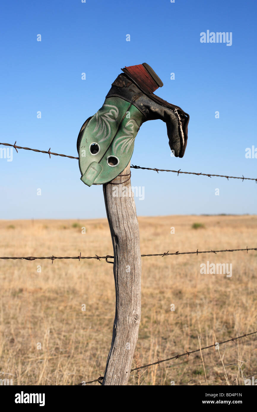 An upside down cowboy boot on a ranch fence in rural Nebraska, USA. Stock Photo