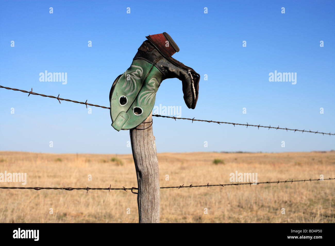 An upside down cowboy boot on a ranch fence in rural Nebraska, USA. Stock Photo
