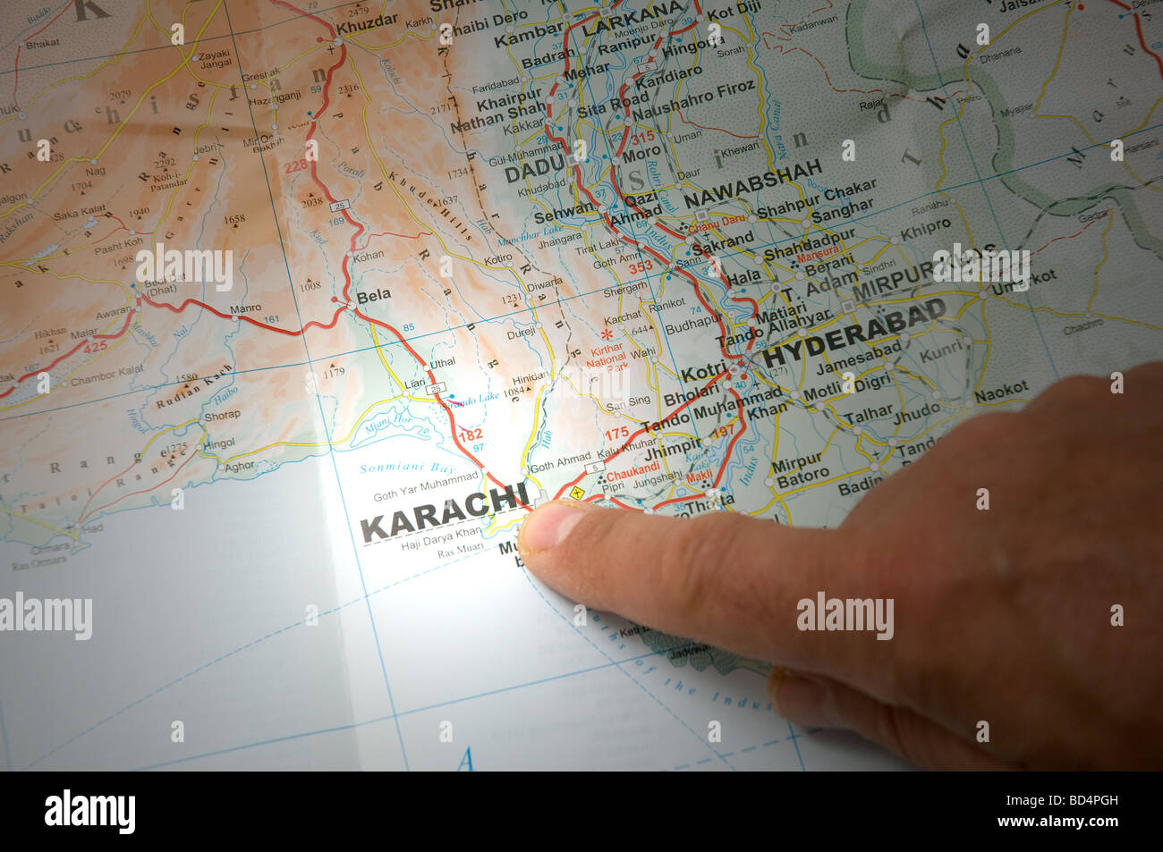 indicate with a finger the city of Karachi on a map Stock Photo