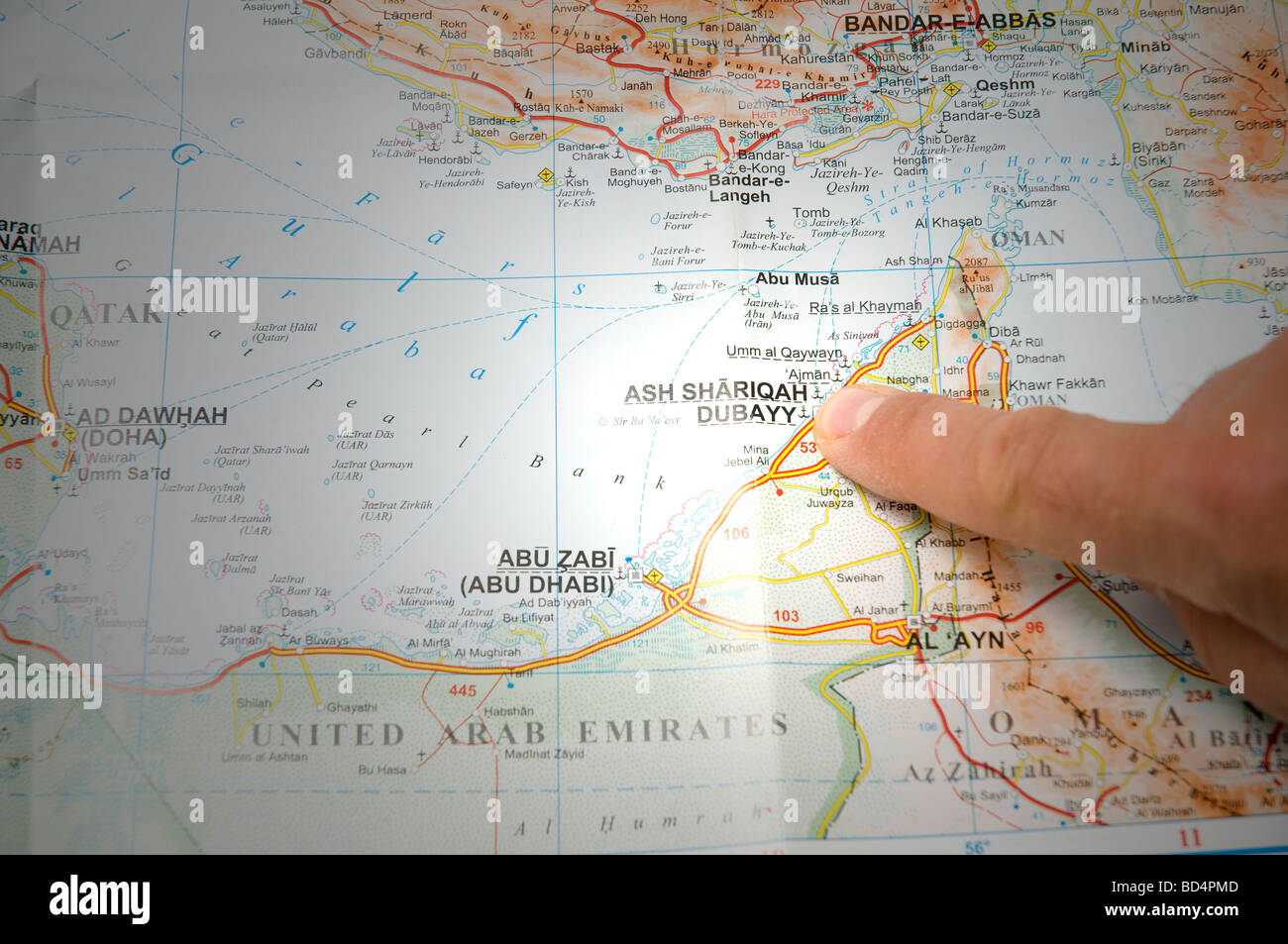 indicate with a finger the city of Dubai on a map Stock Photo