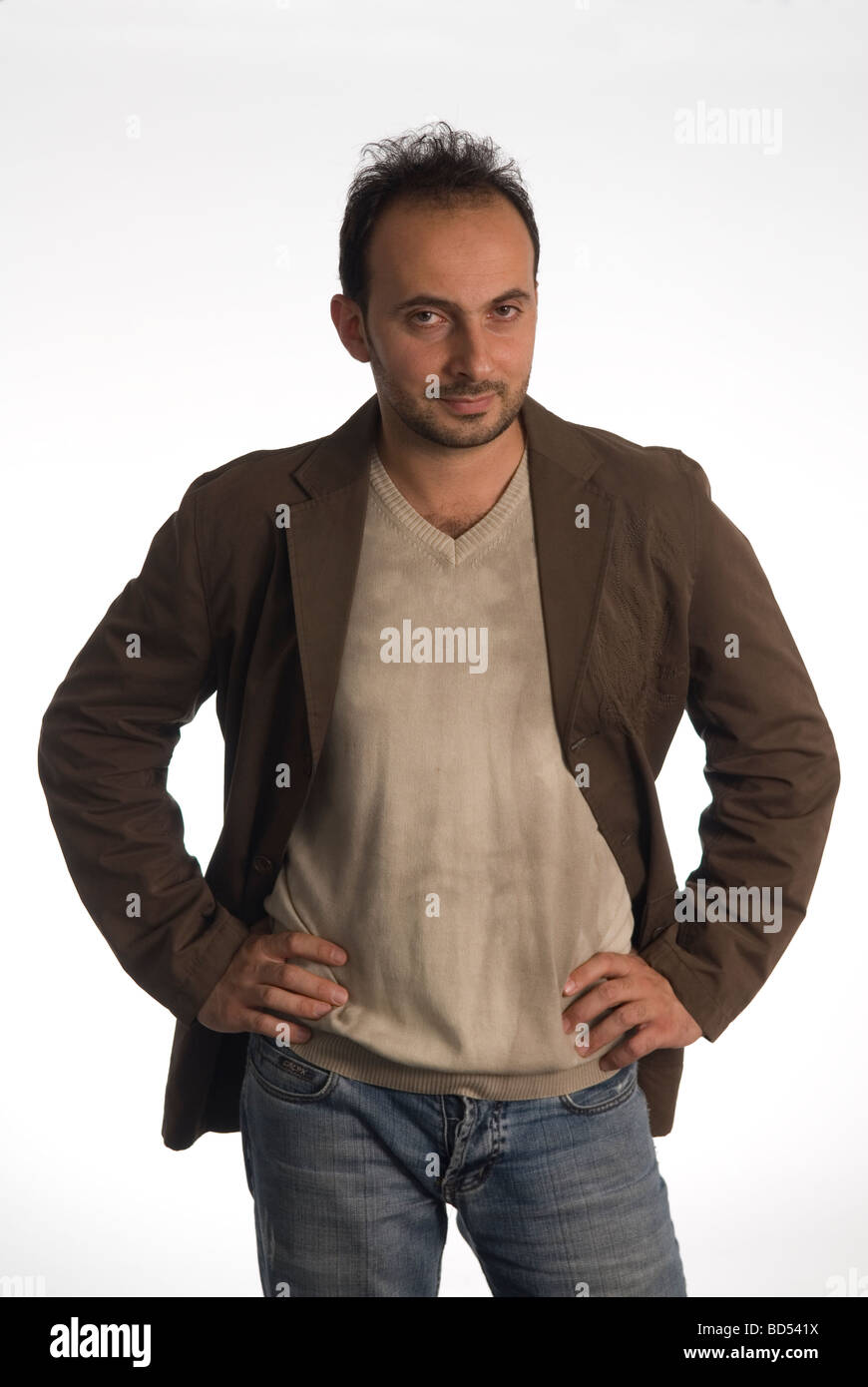 Man standing with hands on his hips against a white background Stock ...