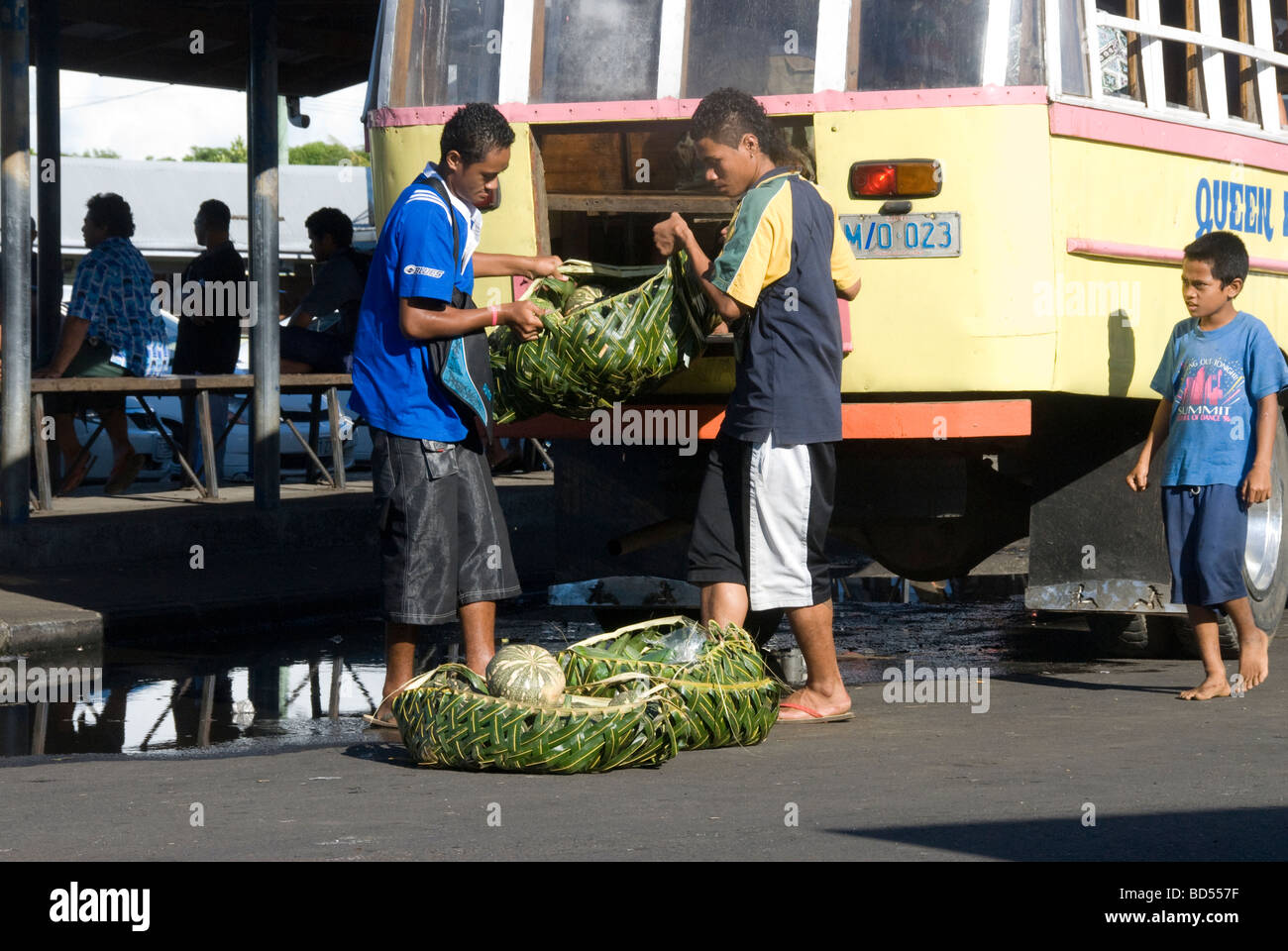 Unloading market produce from brightly coloured bus in Apia, Western Samoa Stock Photo
