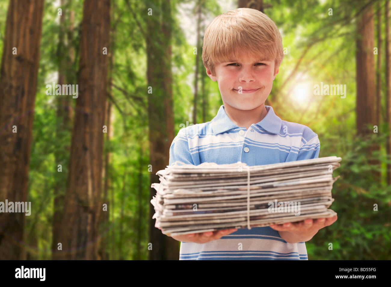 Young boy with stack of newspapers Stock Photo