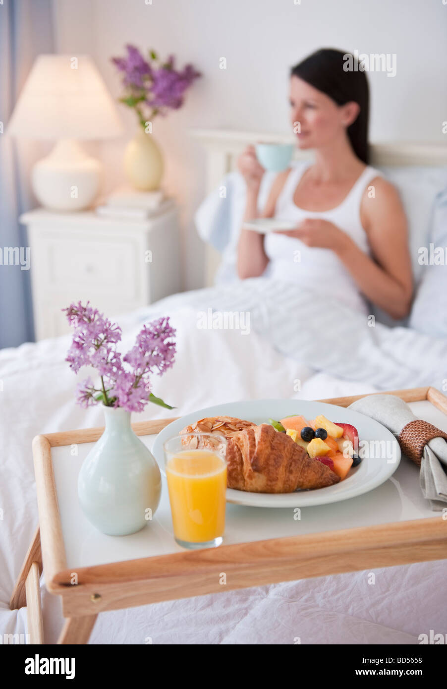 A man bringing a woman breakfast in bed Stock Photo