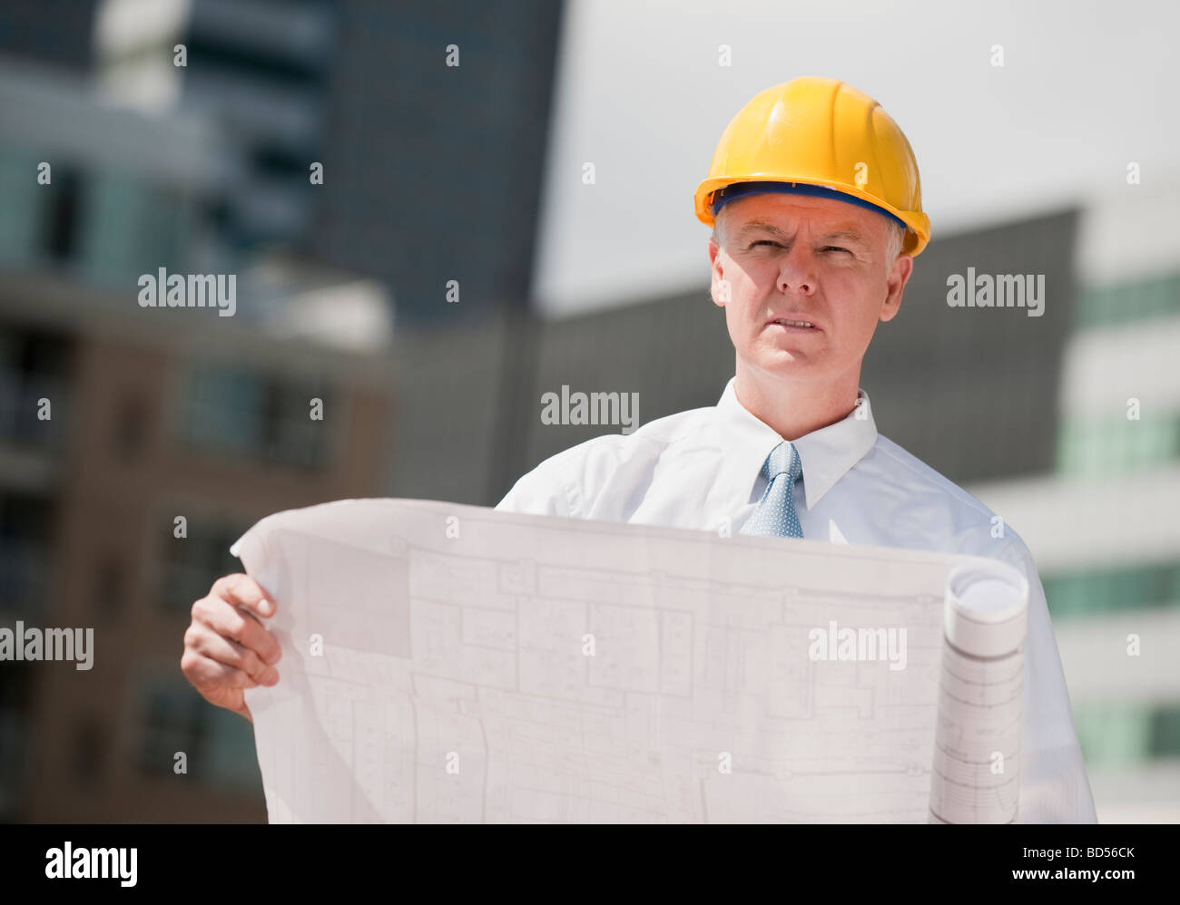An architect holding plans outdoors Stock Photo