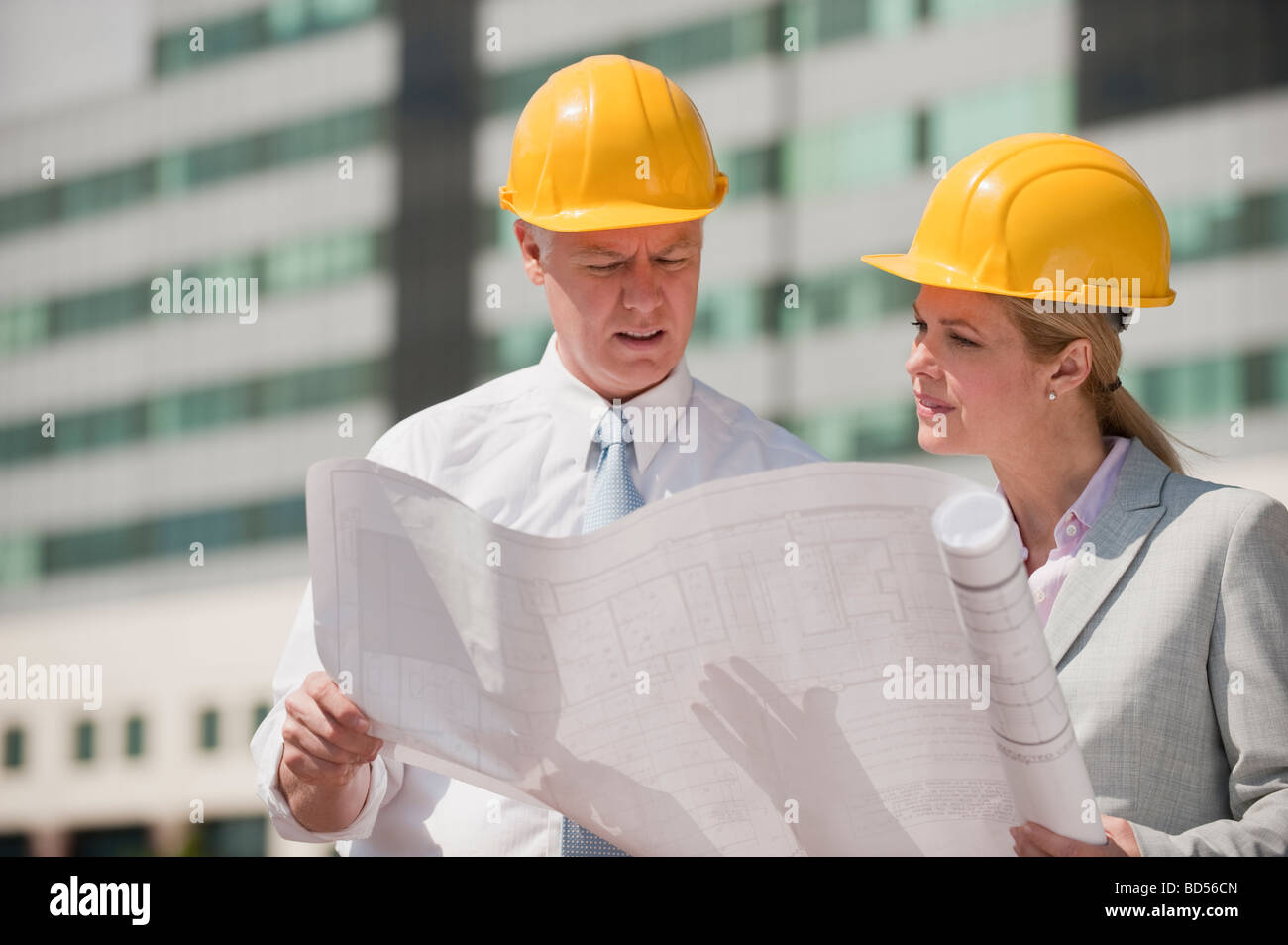 Two architects holding plans outdoors Stock Photo