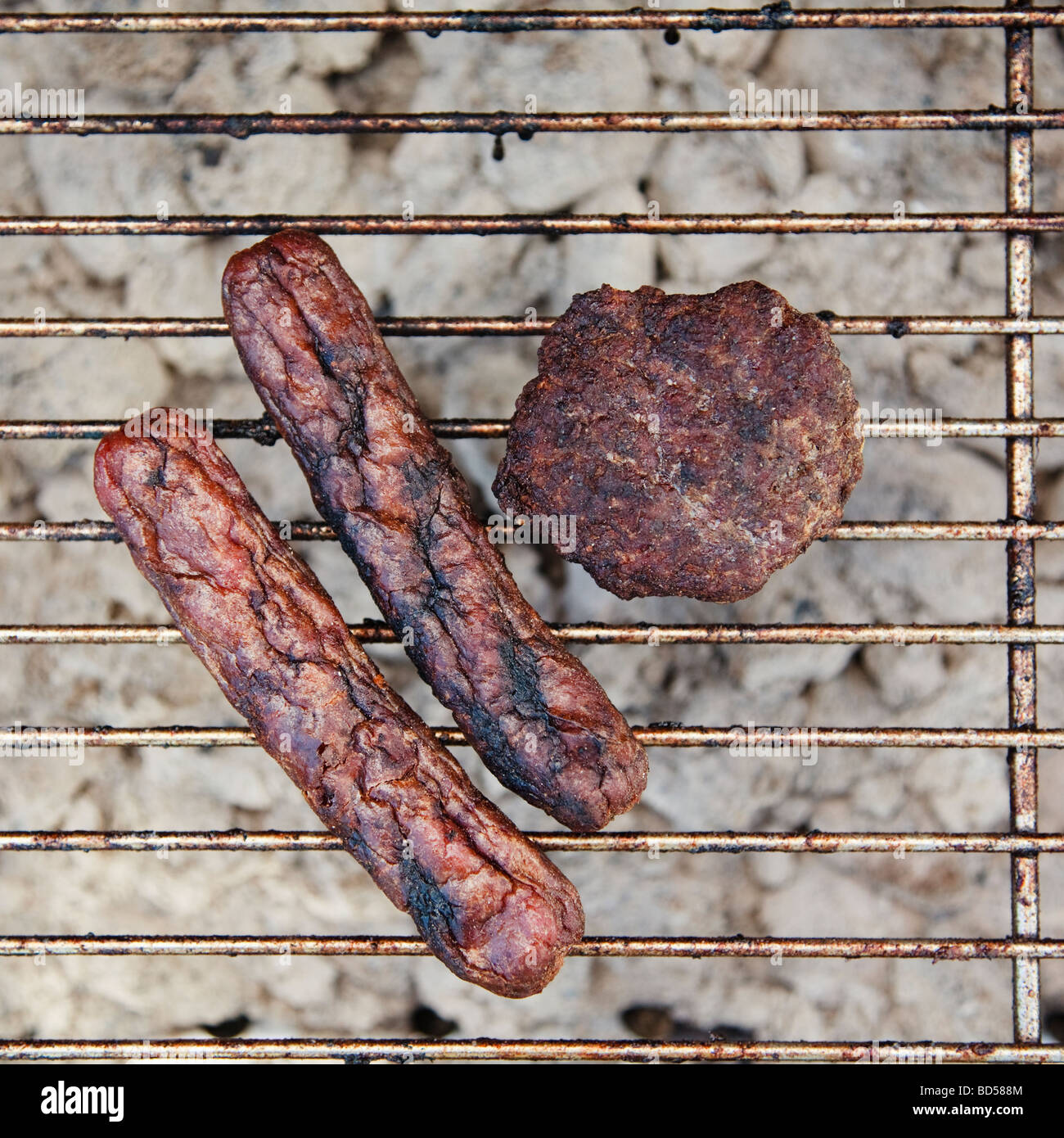Burnt wieners and a burger on a barbeque Stock Photo
