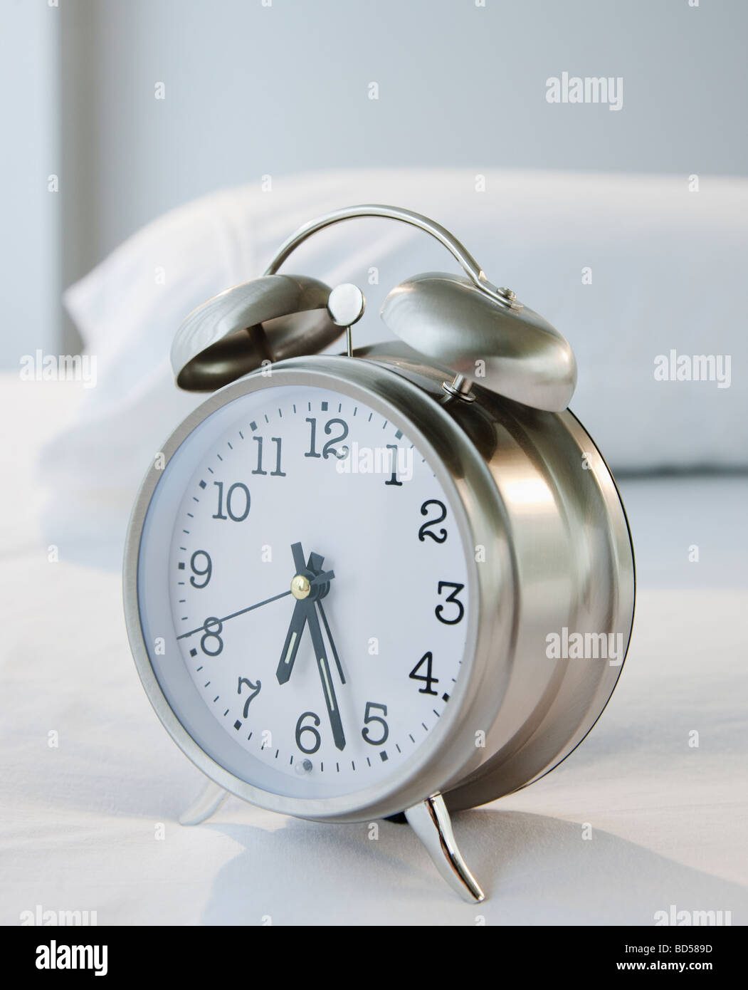 An alarm clock on a bed Stock Photo