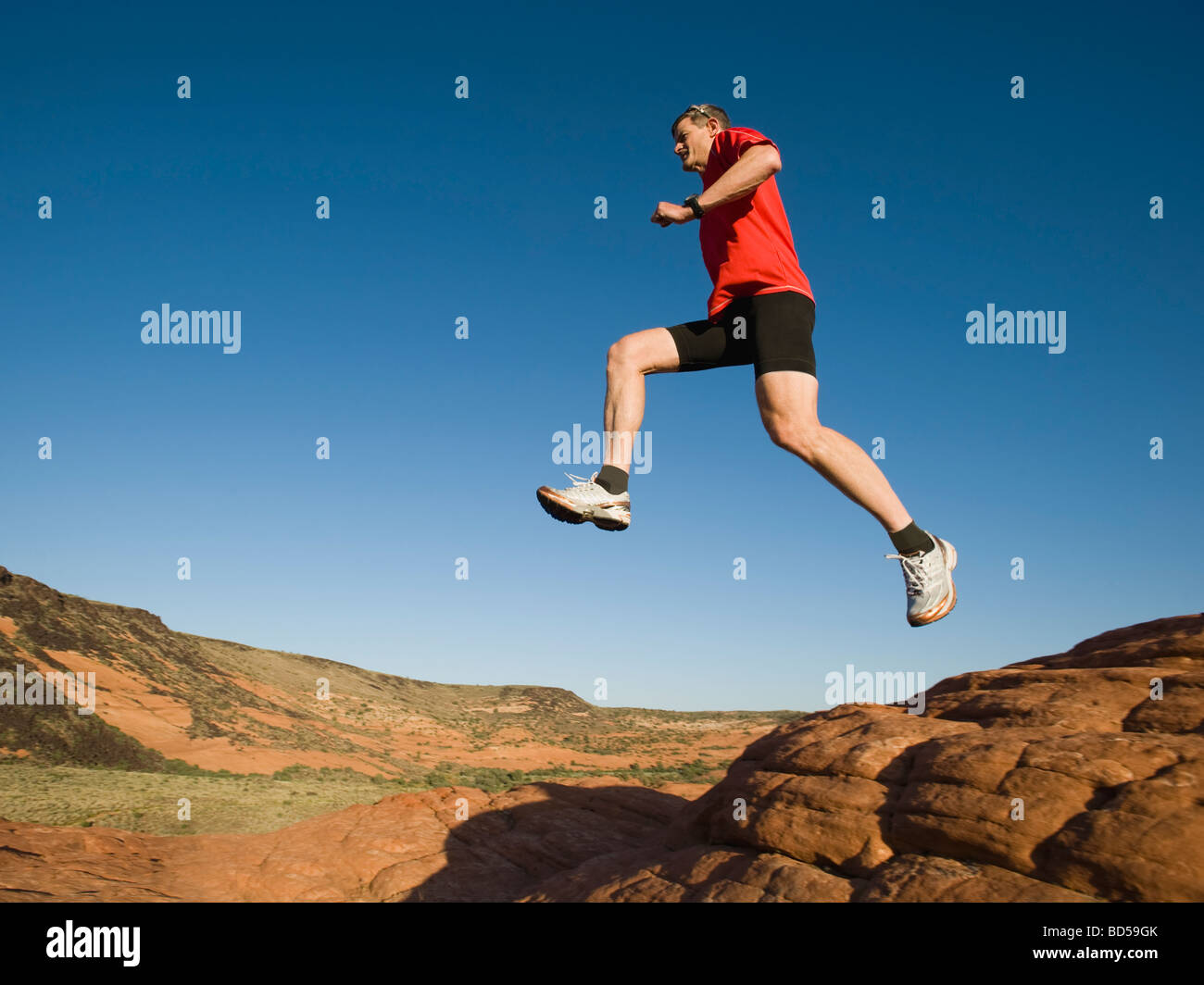 Mature man jumping on rocks hi-res stock photography and images - Alamy