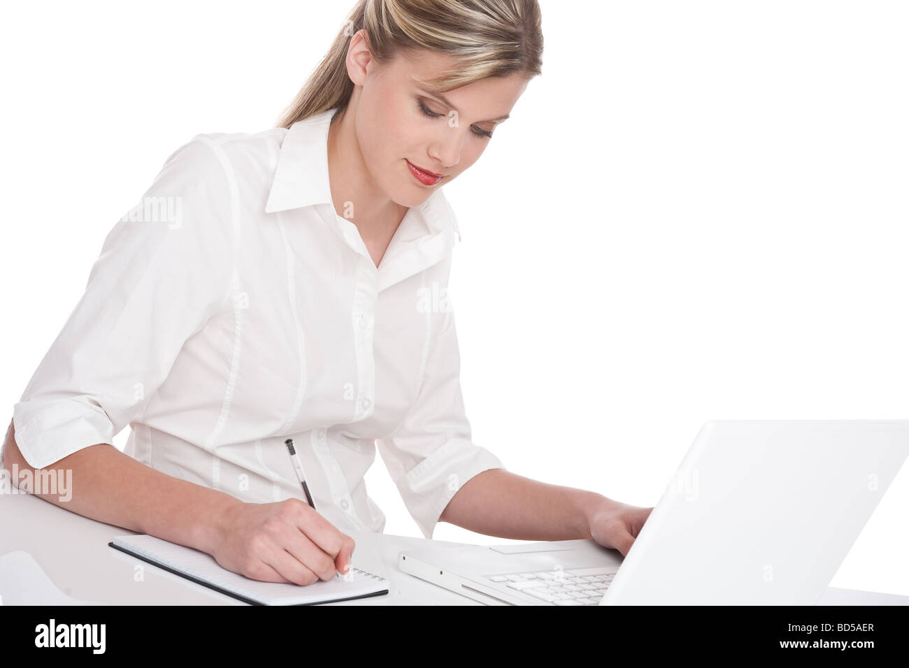 Successful woman working with laptop and writing notes on white ...