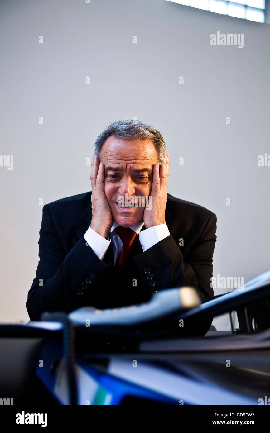 Desperate manager in front of a mountain of folders Stock Photo - Alamy