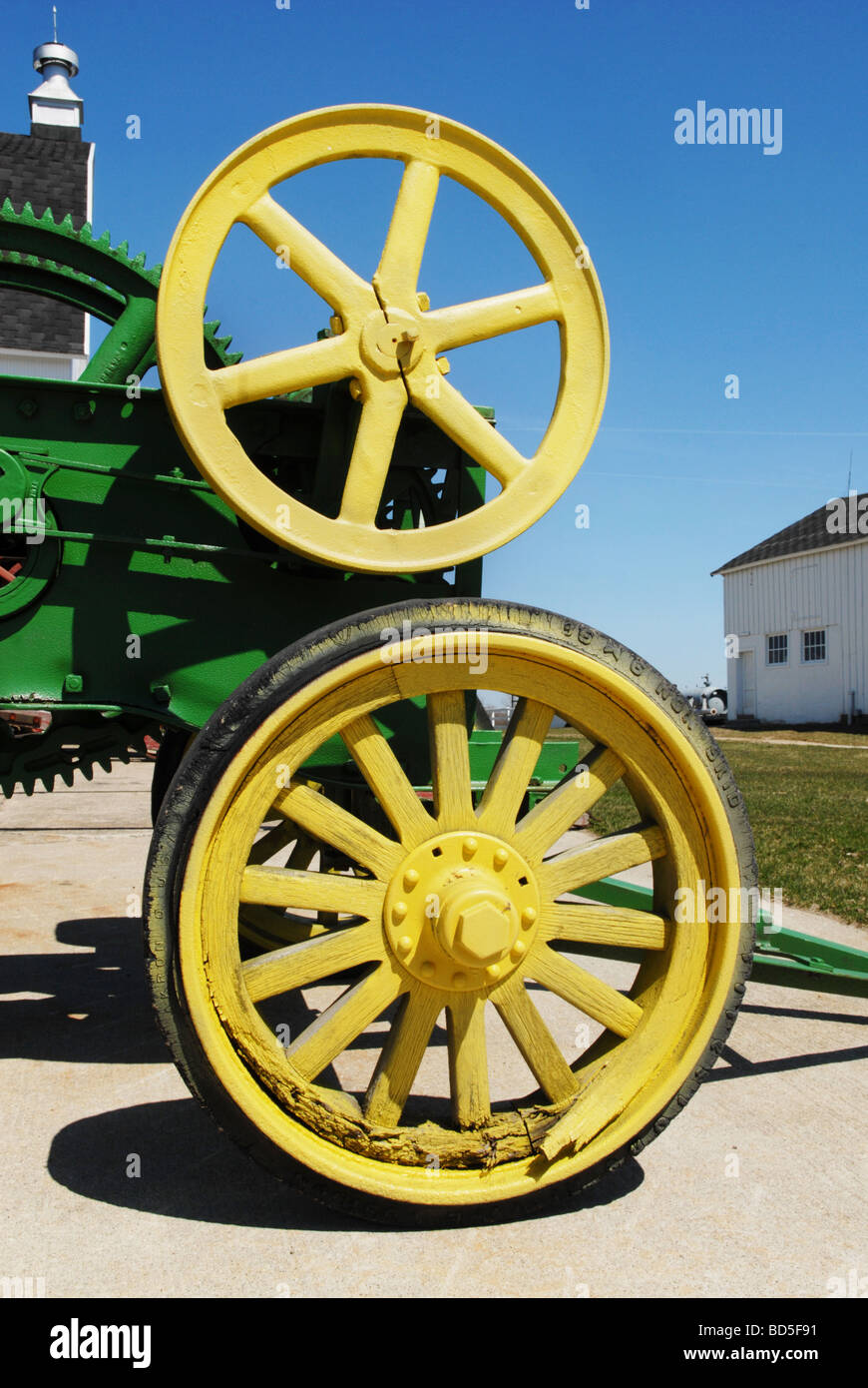 Wheels on an antique farm machine are painted in bright colors Stock Photo