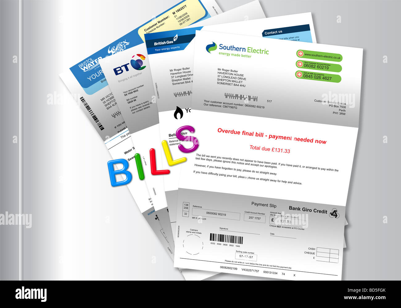 Utility bills (gas electricity telephone and water) attached to white fridge door by magnetic letters spelling ‘BILLS’ Stock Photo