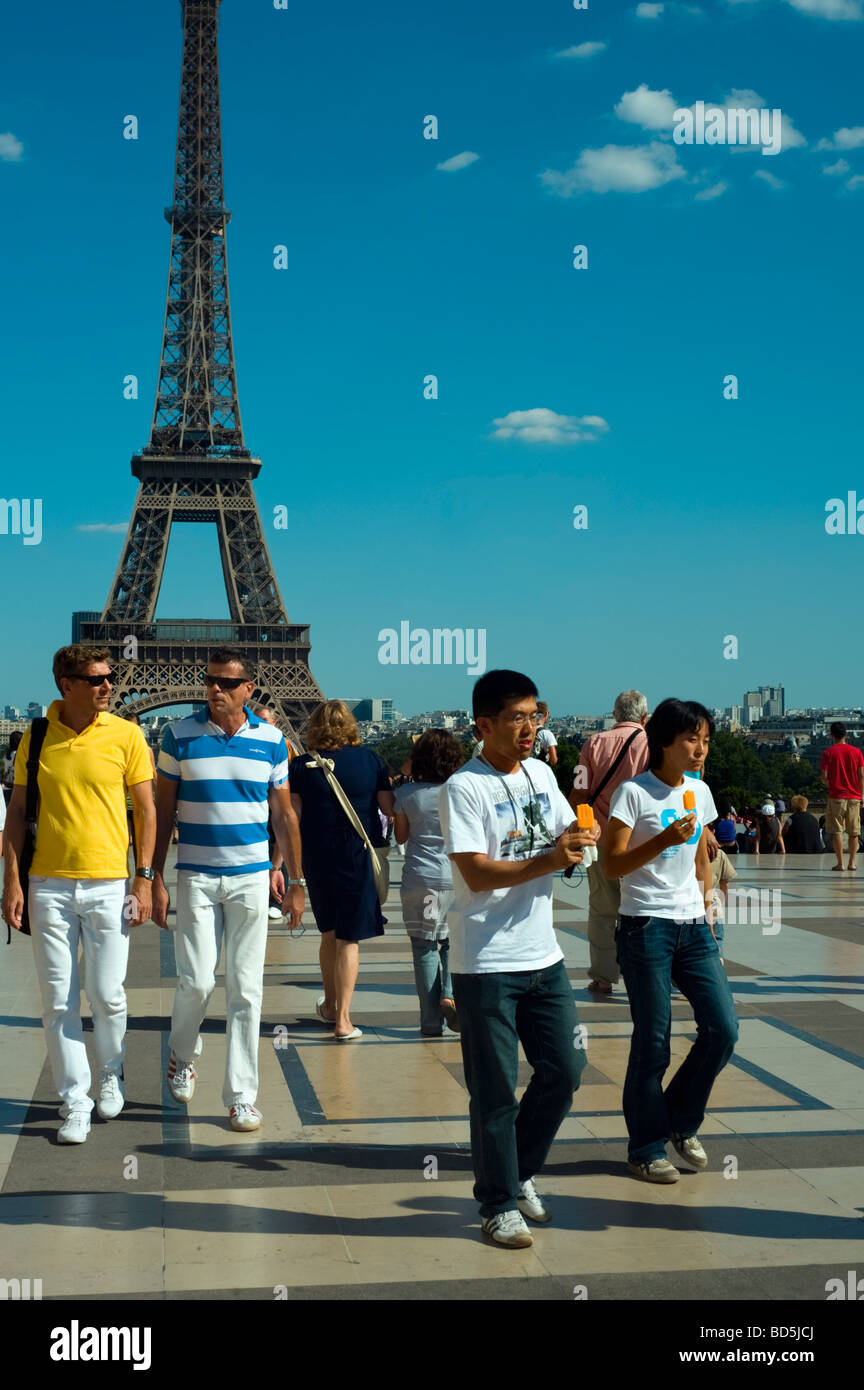 Paris France, Medium Crowd People, Street Scene, Tourist Couples, One Asian Couple, Boys Eating Ice Cream, Walking near the Eiffel Tower Stock Photo